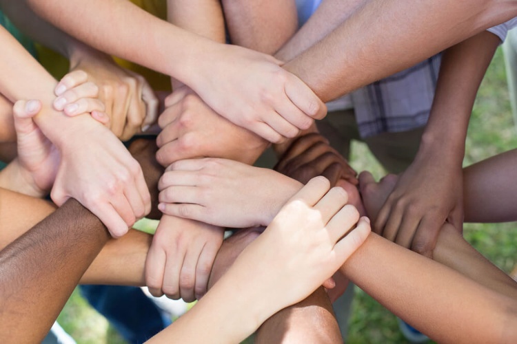 Friends putting their hands together on a sunny day_seo-opt-1