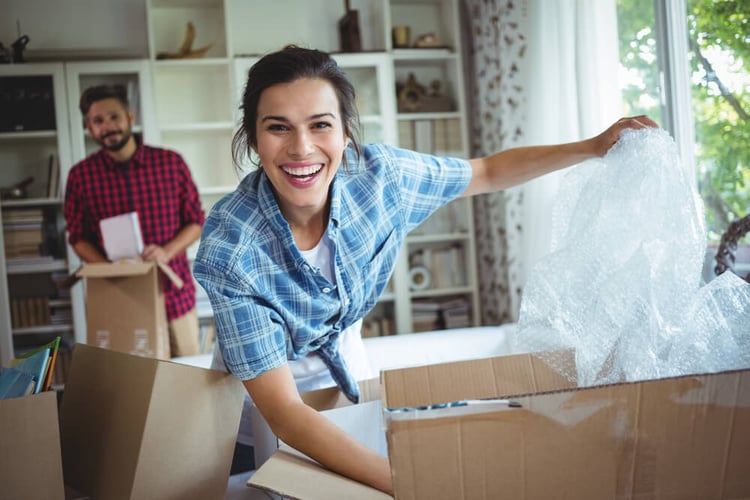 Happy couple unpacking cartons in their new house_seo-opt