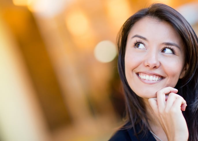 Portrait of a thoughtful woman looking up and smiling