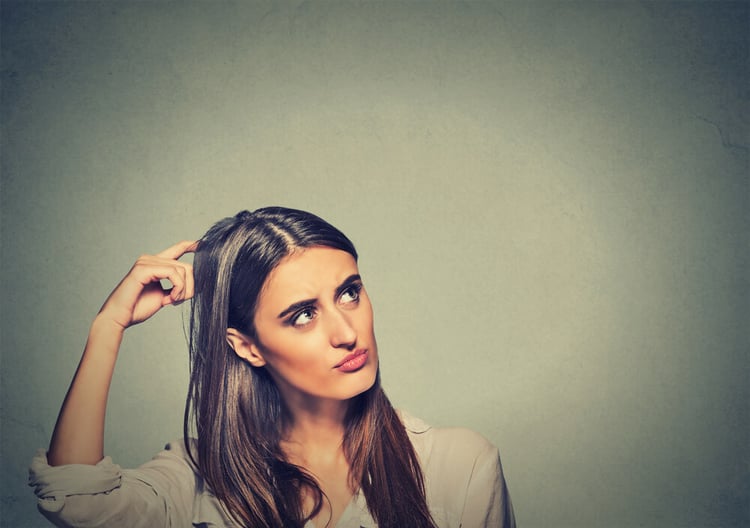 Contused thinking woman bewildered scratching her head seeks a solution isolated on gray wall background. Young woman looking up_seo-opt