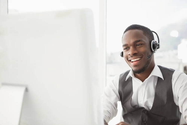 Smiling businessman with headset interacting in his office_seo-opt-correctly-sized