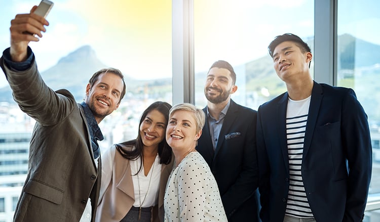 Lohnt sich Instagram für Unternehmen?_smiling-colleagues-taking-a-selfie_2026_©-YuriArcursPeopleimages_900x527px